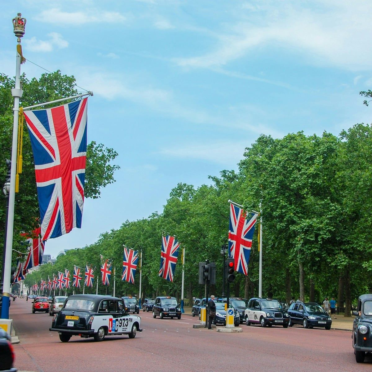 Union flags lining The Mall between St James's Park and Green Park, black cabs on the road