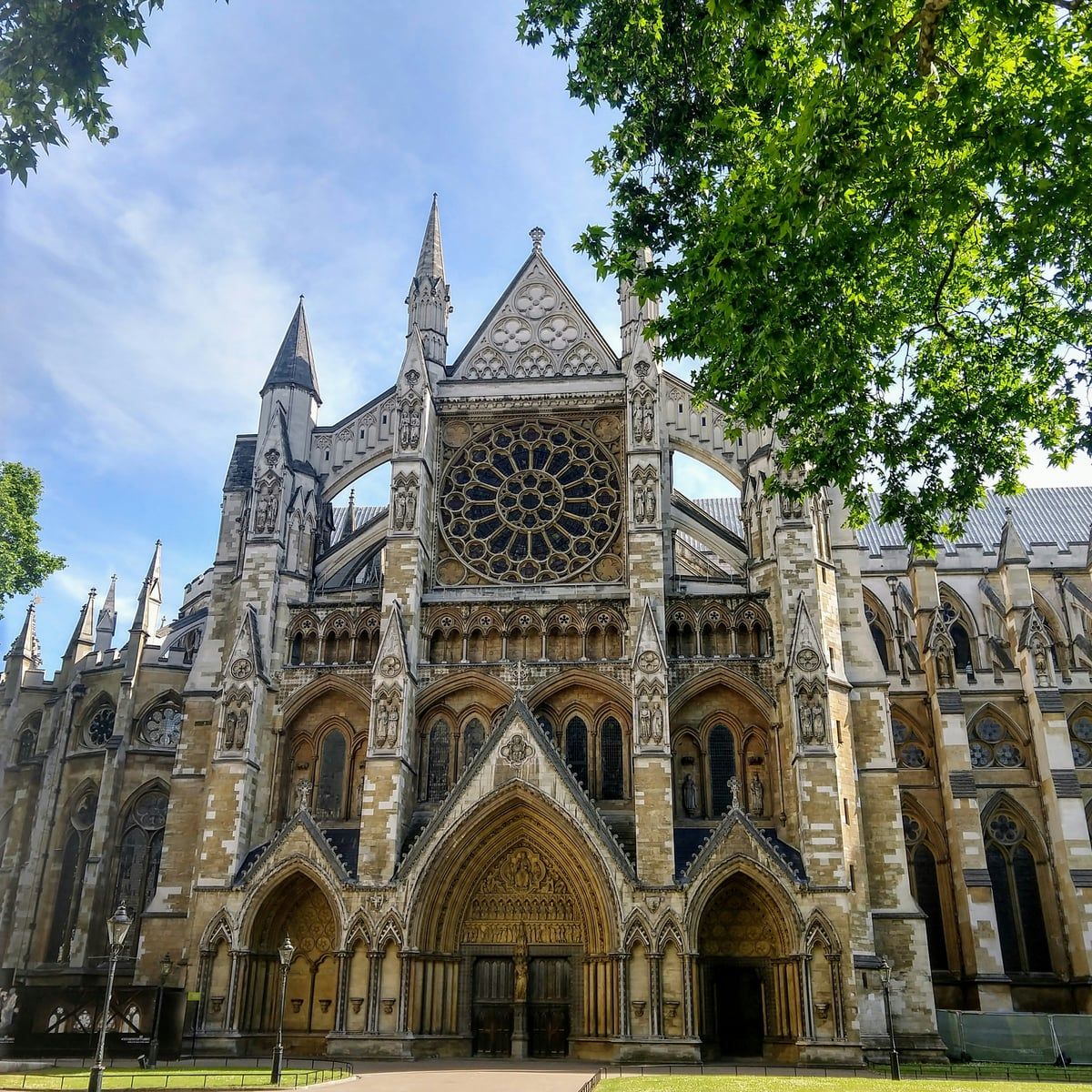 The Gothic north front of Westminster Abbey with its rose window, seen across the lawn on a sunny day