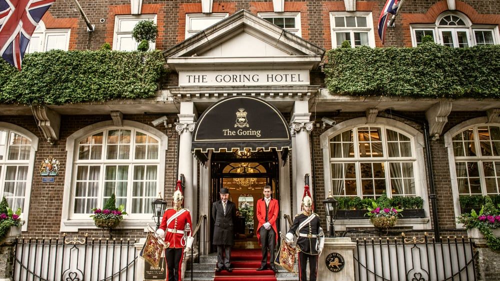 The Goring's canopied front entrance, doormen in red livery beneath flower boxes and Union flags