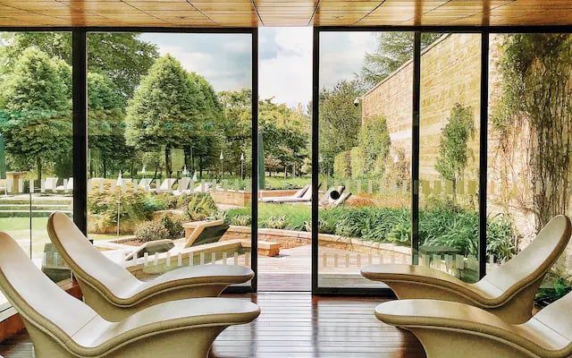 Loungers in the spa at Lucknam Park, floor-to-ceiling windows looking out over the gardens
