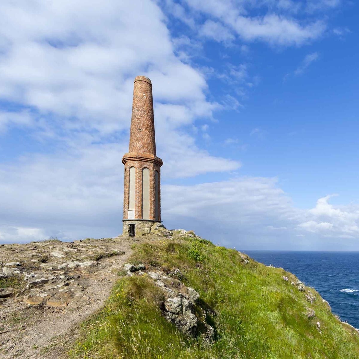 The old mine chimney on the summit of Cape Cornwall, the Atlantic stretching away beside it