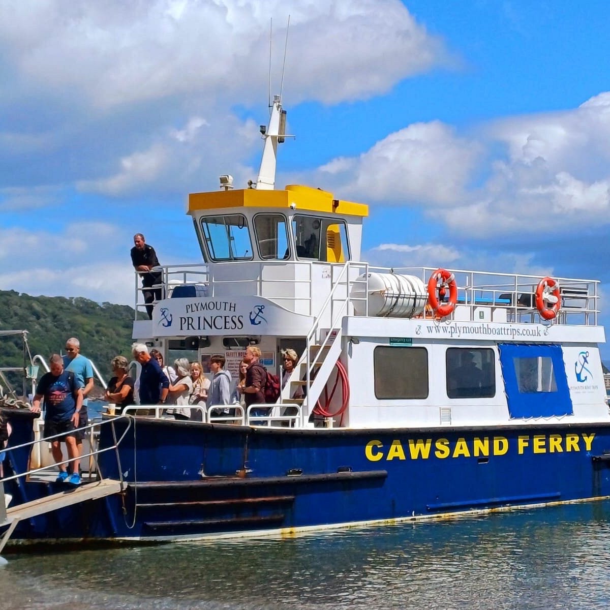 Passengers boarding a small ferry boat at a quayside